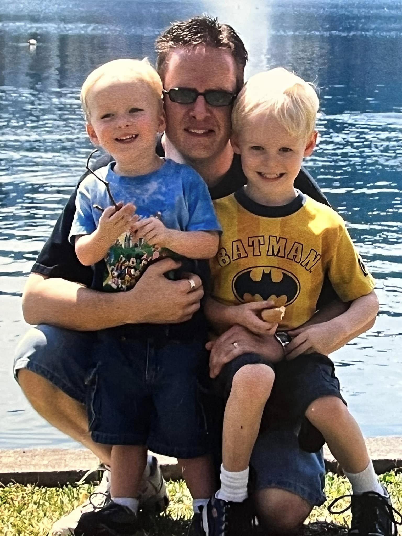 Jim McMahel years ago, kneeling by a lake with his two young sons on his knees
